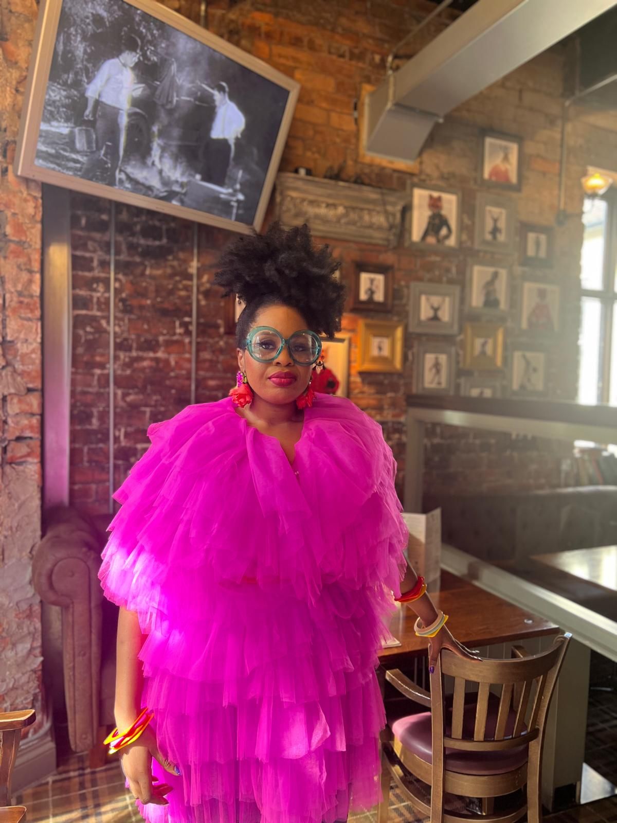 Dr Claire Ogah in oversized glasses and a pink ruffled dress